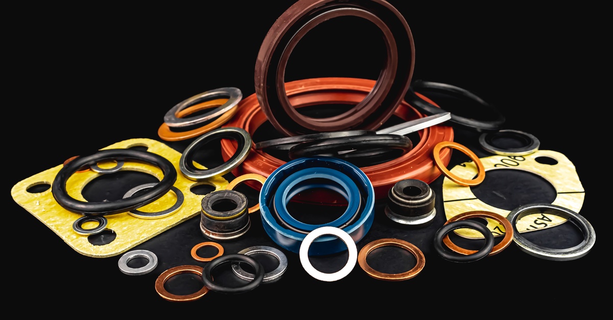 Several o-ring seals and gaskets used in hydraulic systems grouped together in a pile against a plain black background.