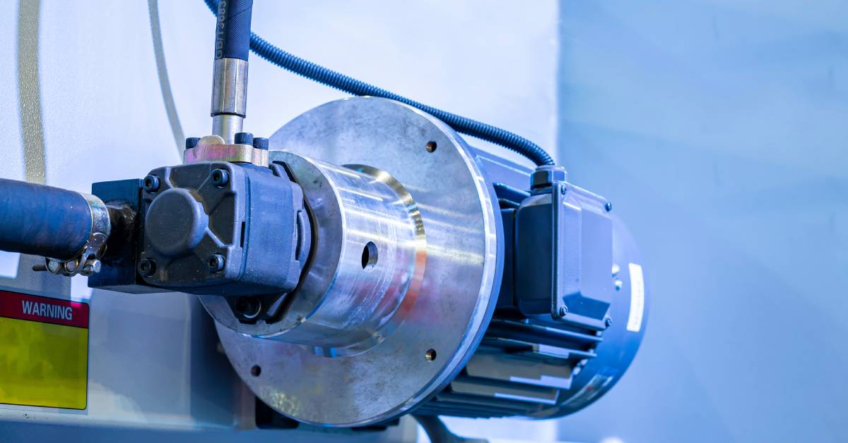 The closeup image of a chrome-and-blue-colored high pressure hydraulic pump used for industrial purposes.